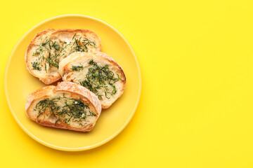 Plate of toasts with garlic and dill on yellow background