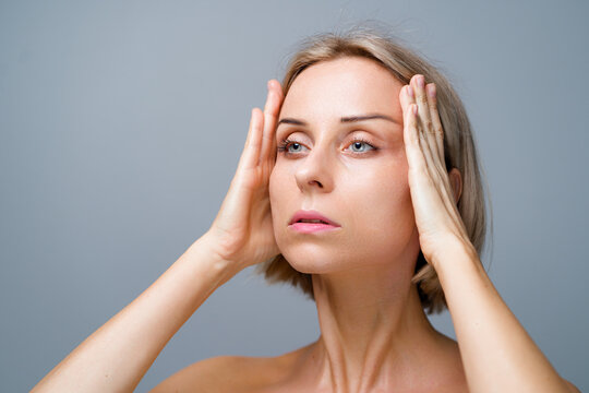 Skin Care. Blonde Woman With Beauty Face Facial Massage. No Makeup. Grey Background.