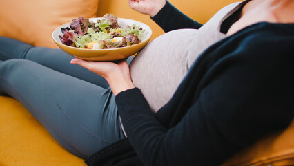 Happy Asian pregnant woman eats healthy food for her unborn baby.