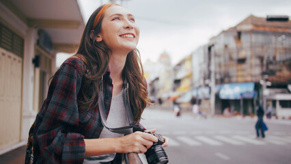 A beautiful woman tourist enjoys taking photos of the city view in Bangkok, Thailand.