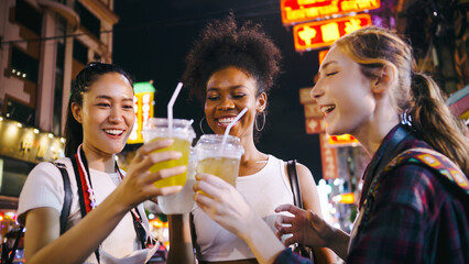 Groups of multi-ethnic female friends are enjoying a night out on Yaowarat Road or Chinatown in Bangkok, Thailand. - obrazy, fototapety, plakaty
