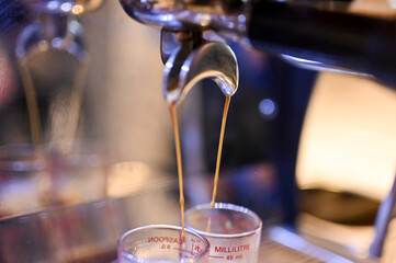 Close up Espresso machine making coffee, golden espresso flowing. Coffee espresso.(Selective Focus)