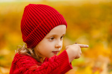 A close-up portrait of a child holding a bright red ladybug in autumn. © ShunTerra