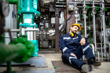 Overworked employee sleeping in factory during night shift.