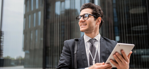 Uses a tablet reads a message manager a man in a business suit goes to the office to work