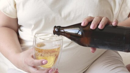 pregnant woman pour beer from bottle to glass.big advanced belly in background.third trimester.female wish to drink cold beverage in hot summer day.alcohol damage the health forbidden for pregnant - Powered by Adobe