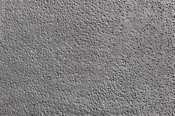 Textured background in silver gray color. The surface is dotted with small craters.