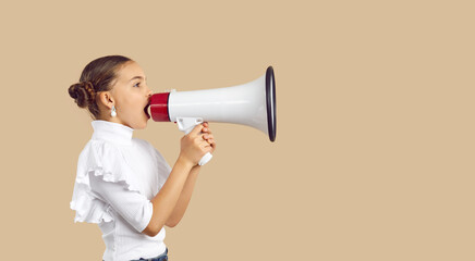 Child speaking through megaphone. Kid making loud announcement. Side view of pretty schoolgirl dressed in beautiful white top holding loudspeaker, sharing important message or promoting event for kids