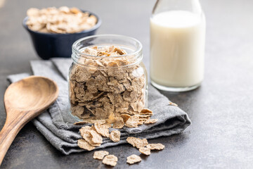 Whole grain cereal flakes. Wholegrain breakfast cereals in jar on kitchen table.