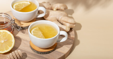 Obraz na płótnie Canvas Cup of hot tea with ginger, honey and lemon on the beige background web banner with copy space for text