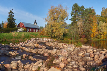 Fototapeta na wymiar Northern European landscape in Finnish Kellokoski: golden autumn, rapids, Kerava river, sunny day, church near.