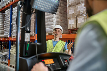Storehouse manager supervising the lift truck operator