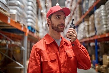Man with a handheld transceiver standing in the warehouse © zinkevych