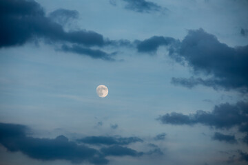 wschód pełnia księżyca na tle niebieskiego nieba i ciemniejszych chmur, full moon - obrazy, fototapety, plakaty