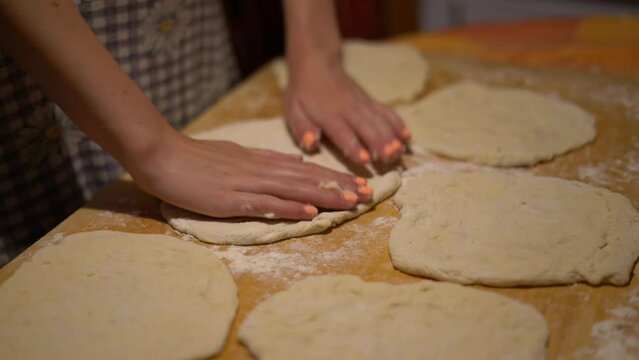 Hands close up stretching dough for steps in Hungarian food Langos, home kitchen