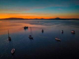 Naklejka premium Aerial sunrise waterscape with boats and high cloud