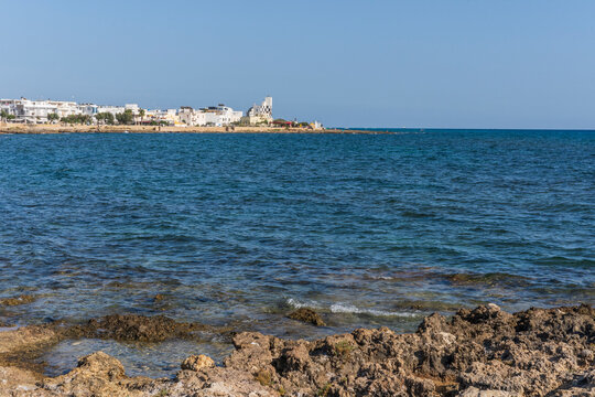 Scenic view of Torre San Giovanni and its rocky shore, with lighthouse in the background, marina di Ugento, Salento, Puglia
