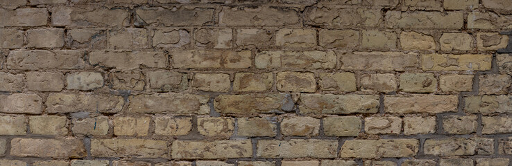 Wide weathered beige brown brick wall background