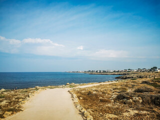 Rocky shore of Capilungo, Salento, Puglia, Southern Italy, with walking path and vegetation, in a...