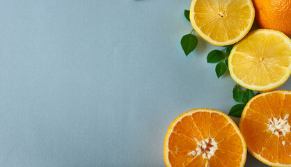 Lemon and orange halves with leaves on gray background with space for text. The concept is vitamin...