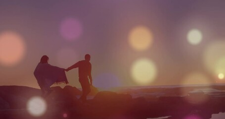 Animation of glowing spots over diverse couple holding hands - Powered by Adobe