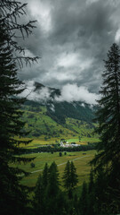 Swiss Mountain Valley on a Cloudy Day, featuring misty peaks, rolling hills, and serene landscapes, capturing the dramatic and moody beauty of the Alps
