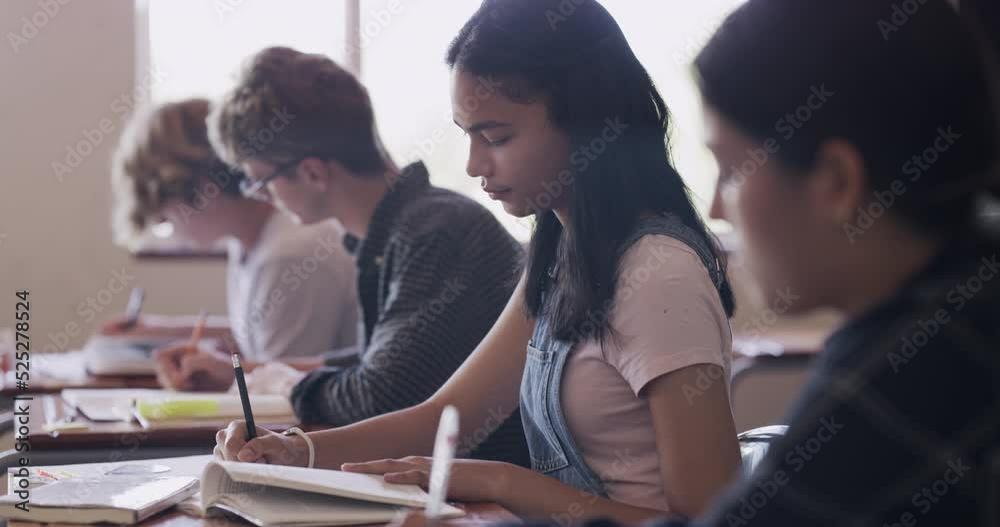 Leinwandbilder school girl writing in book in classroom, student learning for education at table and studying for e
