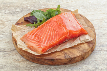 Raw salmon fillet over board