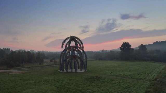 Nikola-Lenivets, KALUGA REGION, Russia - 15 may 2022. Ugra National Park, park of modern art objects in nature. Unusual sculpture Ugruan made of multicolored metal wire., Russia. Sunset.