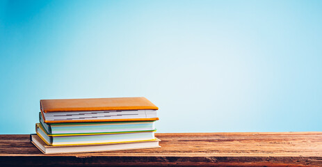 A stack of books and notebooks on desk or shelf. Education, studying and back to school concept