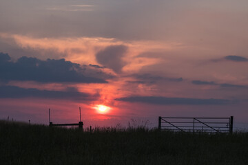 Summer sunset sky over a farm field