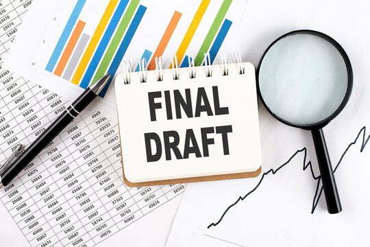 FINAL DRAFT text on notebook on the graph background with pen and magnifier