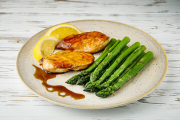 boiled green asparagus and grilled chicken on a white wooden rustic background