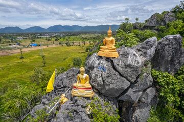 The gold Buddha statue on the stone of the mountain at Wat Cha Am Khiri, Phetchaburi, Thailand