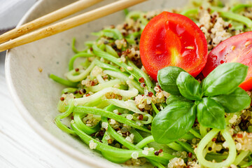 zucchini noodles with quinoa on a white background