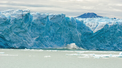 Fototapeta na wymiar A giant chunk of ice breaking off the magnificent Perito Moreno Glacier in Patagonia, Argentina.