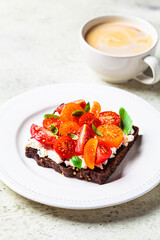 Rye toast with cream cheese, tomatoes and basil. Healthy breakfast recipe.