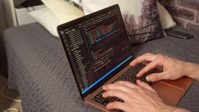 hands typing on a keyboard creating a web-based computer program in an editor on a laptop computer