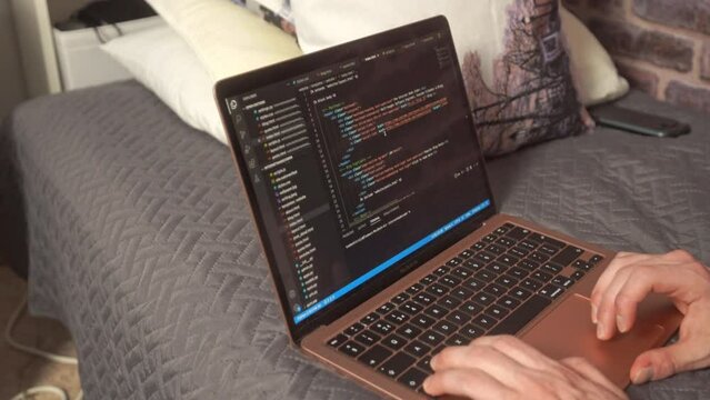 A student scrolls past code for website development on a laptop computer on a modern programming editor