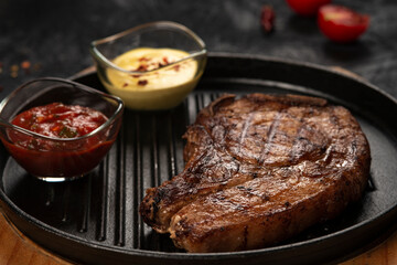 pork steak with vegetables in a black iron pan