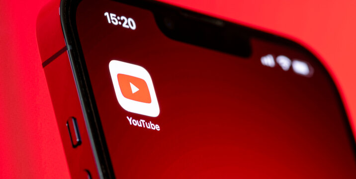 Youtube application on smartphone screen on red background, Social media platform on mobile phone on red background.August 23, 2022, Bangkok, Thailand