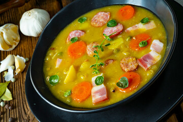 Hearty rustic pea soup with bacon and sausage