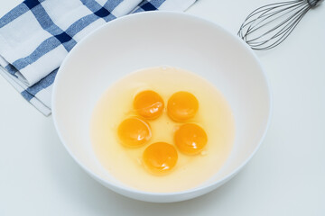 Raw chicken eggs in  white bowl on the table.