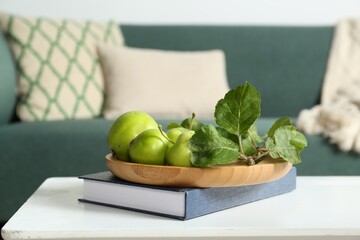 Fresh green apples on white wooden table in living room, space for text