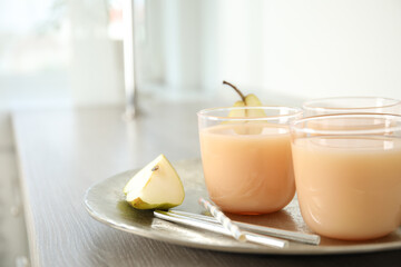 Tasty pear juice and cut fruit on wooden table, closeup