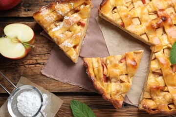 Traditional apple pie and ingredients on wooden table, flat lay