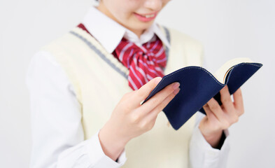 白背景で本を読む女子高生　顔無し