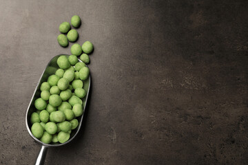 Tasty wasabi coated peanuts on grey table, flat lay. Space for text