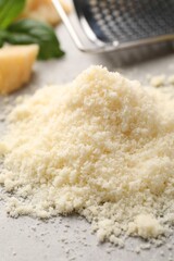 Pile of grated parmesan cheese on light table, closeup
