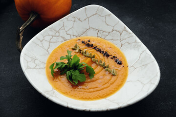 Pumpkin cream soup with seeds and arugula